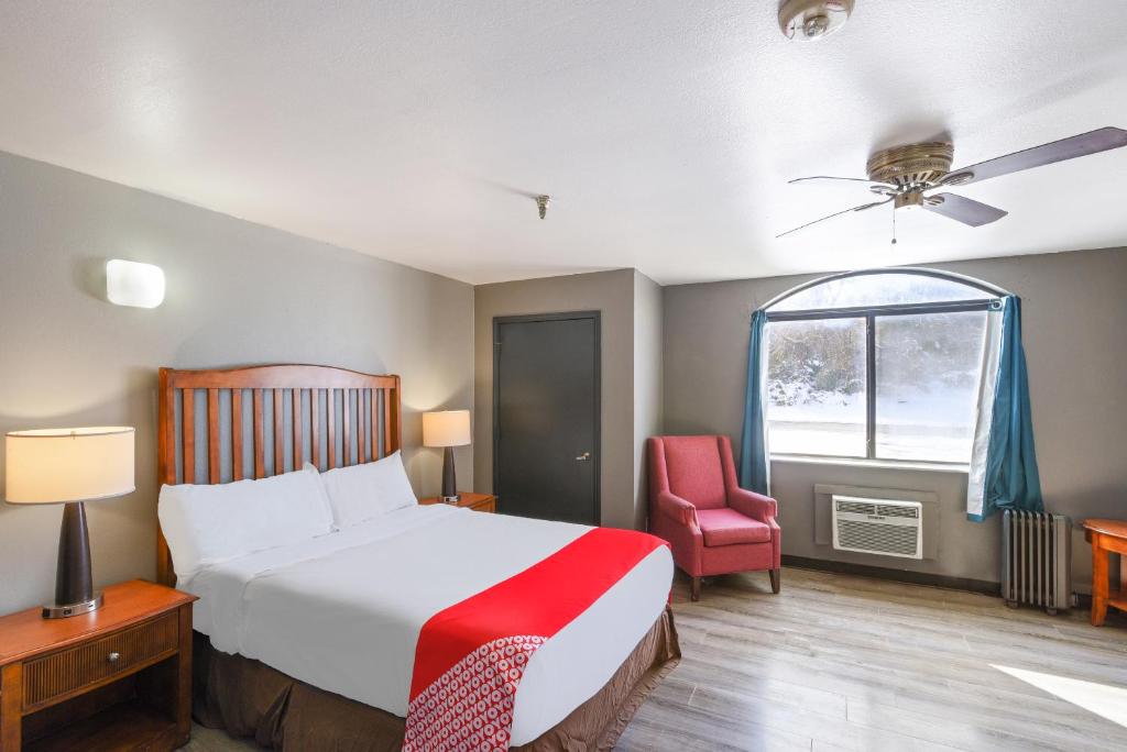 a bedroom with a bed and a chair and a window at OYO Hotel Edmond - University of Central Oklahoma in Edmond