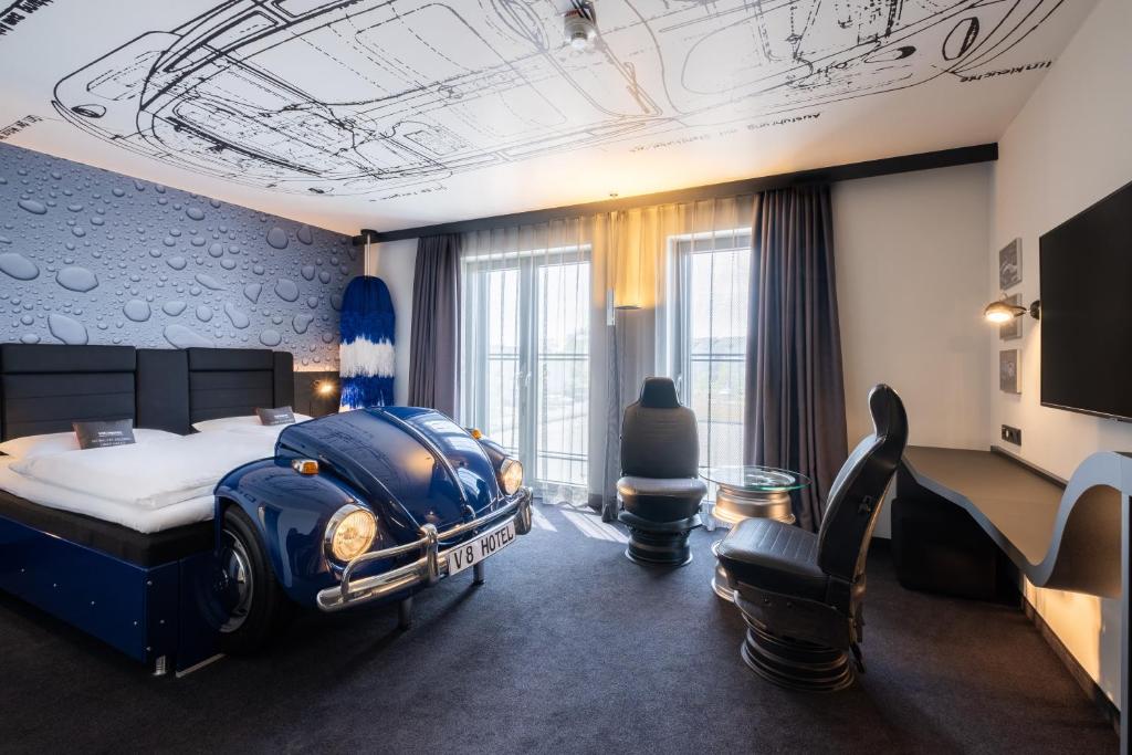 a hotel room with a bed with a car on the ceiling at V8 Hotel Köln at MOTORWORLD in Cologne