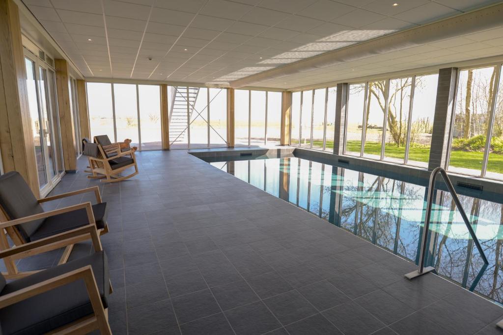 - une piscine dans un bâtiment avec fenêtres dans l'établissement Boutique Hotel Texel, à De Cocksdorp