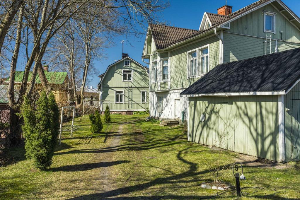 an old house with a garage in a yard at Newly renovated apartment in a woodenhouse from 1910 in Martti! in Turku