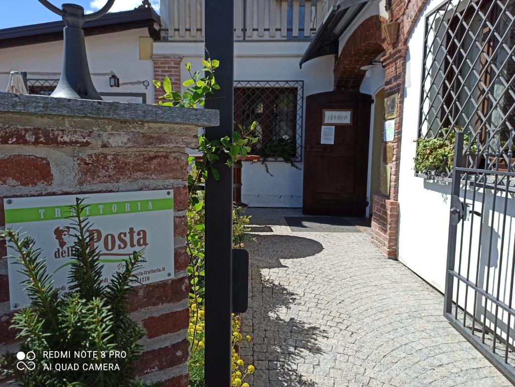 une rue avec un panneau devant un bâtiment dans l'établissement Trattoria della Posta, à Peveragno