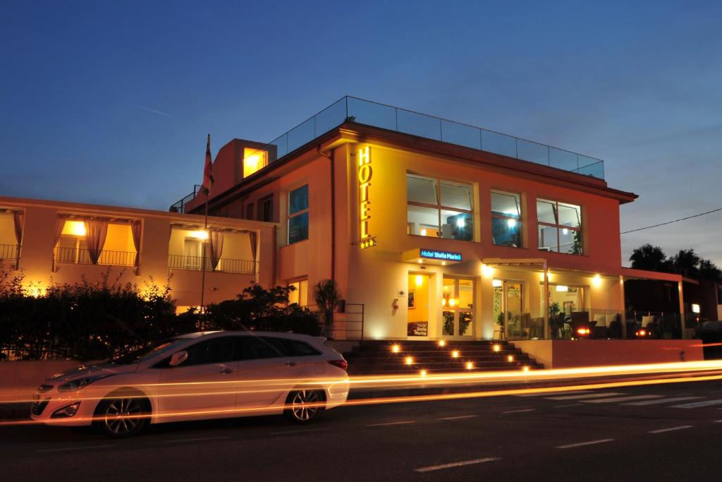 聖特奧多羅的住宿－斯泰拉馬瑞娜酒店，夜间停在大楼前的汽车