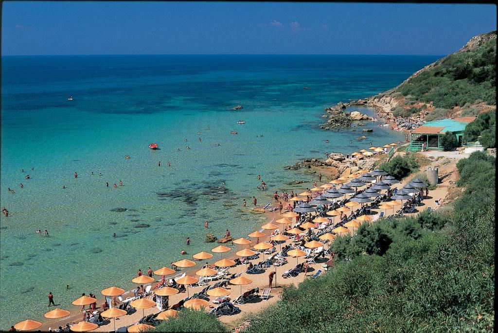 una playa con muchas sombrillas y gente en el agua en iGV Club Vacanze Le Castella, en Le Castella