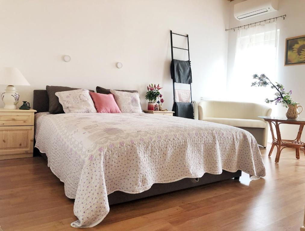 een slaapkamer met een bed met roze kussens bij Balaton Apartman Paloznak in Paloznak
