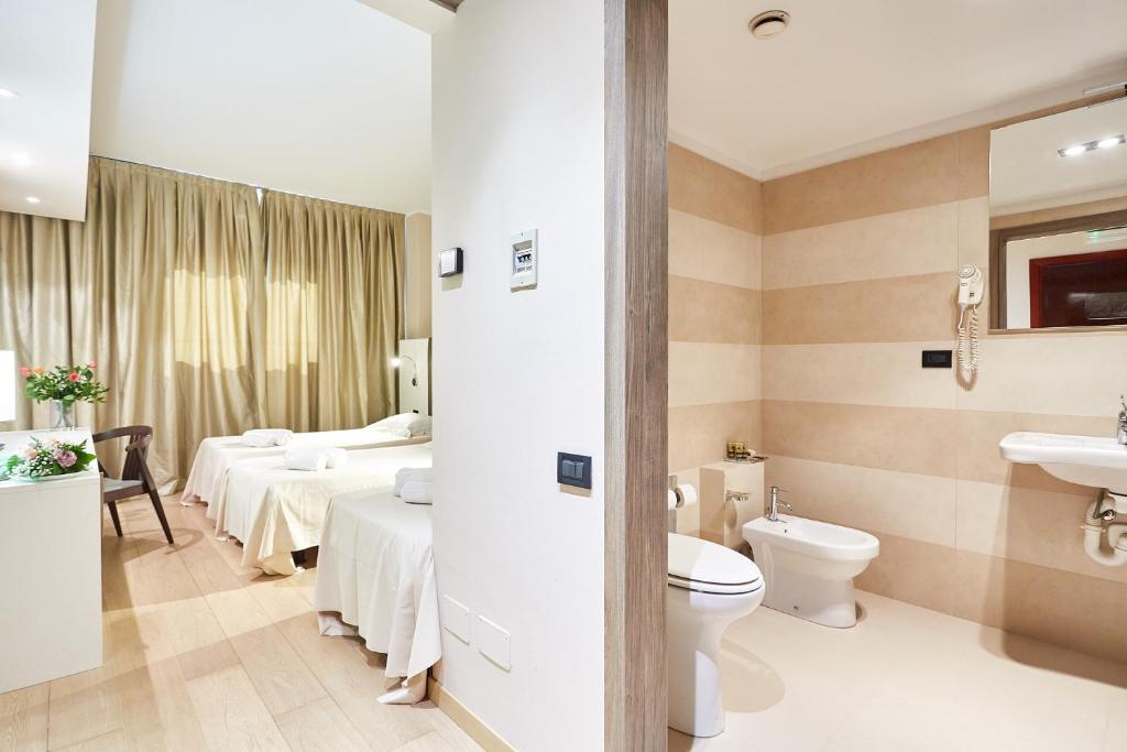 łazienka z 2 łóżkami, toaletą i umywalką w obiekcie Ferretti MajesticHouse w mieście Castenedolo