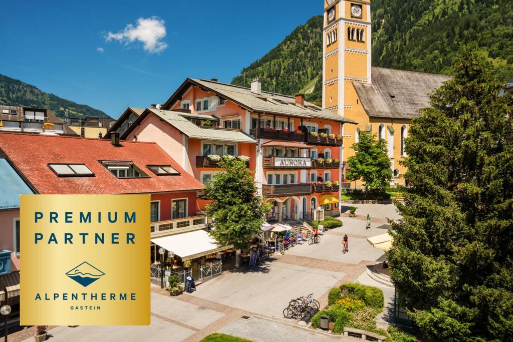 a sign in front of a building with a clock tower at Aurora Appartements inklusive freiem Thermeneintritt in Bad Hofgastein