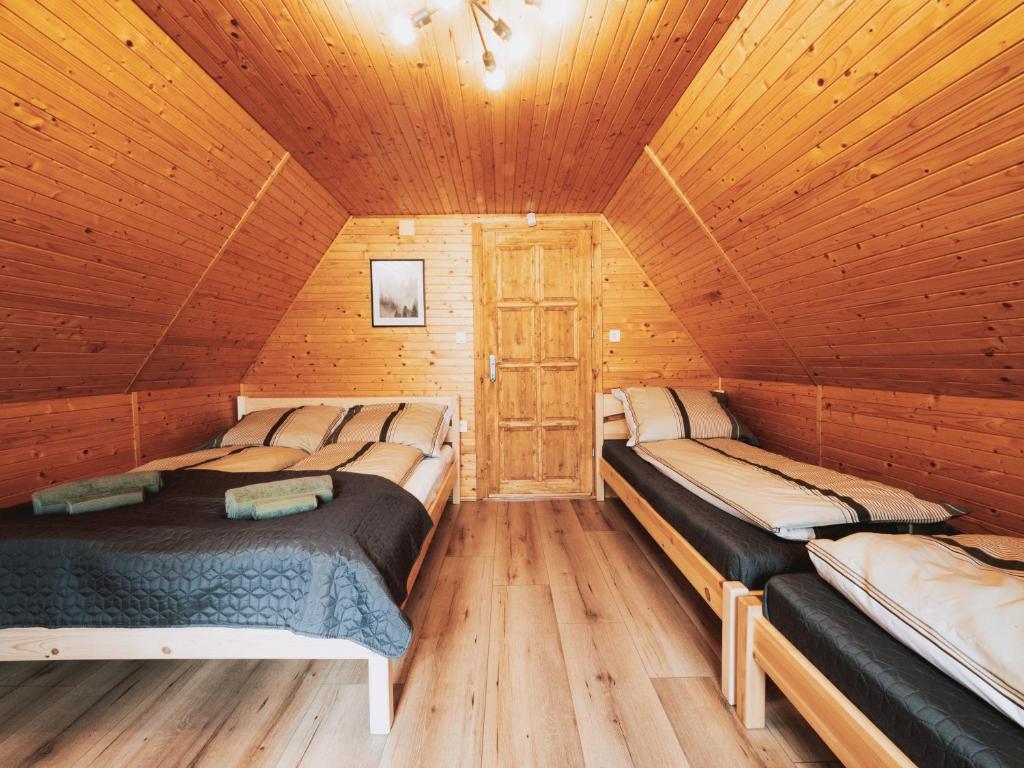 a room with two beds in a wooden cabin at Kedvesem Noszvaj in Noszvaj