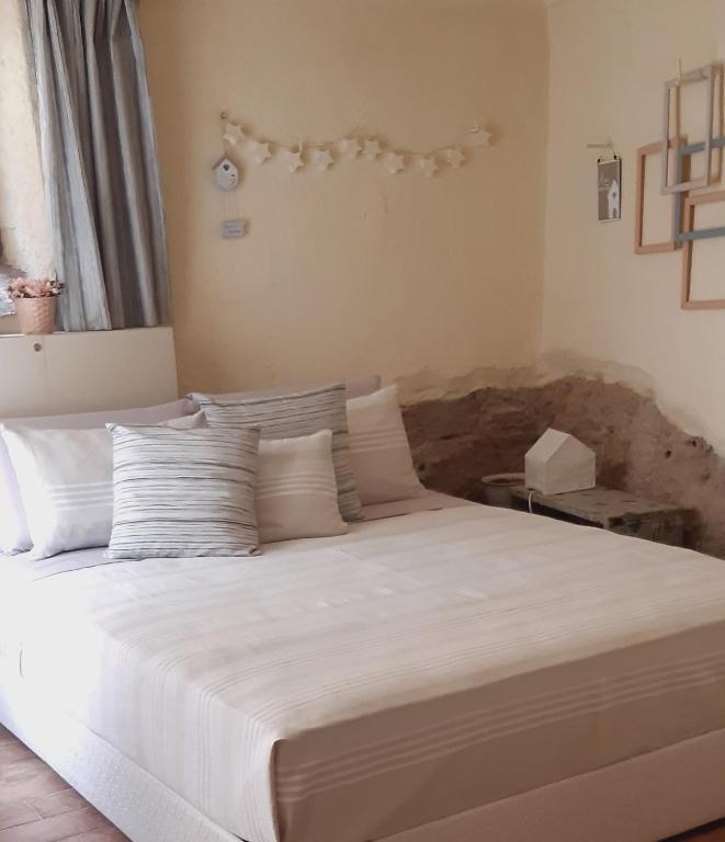 a bedroom with a large bed with white sheets and pillows at Tavernetta vicino Lago Trasimeno in Magione