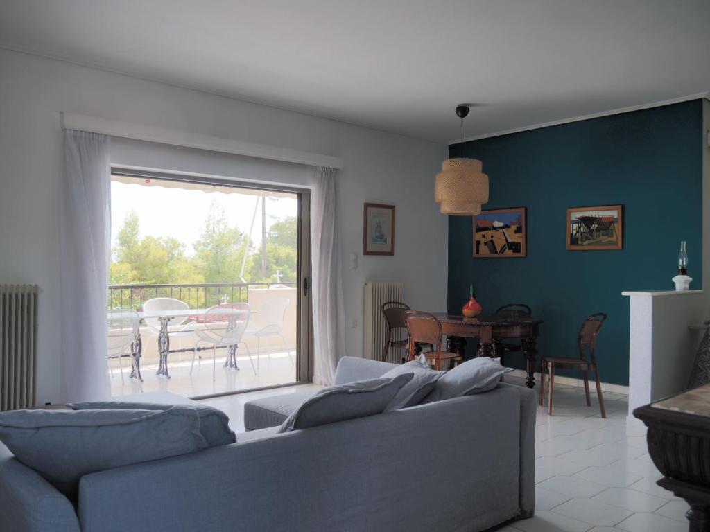 - un salon avec un canapé et une vue sur une terrasse dans l'établissement Villa Kavos - Isthmia Corinth, à Isthmia
