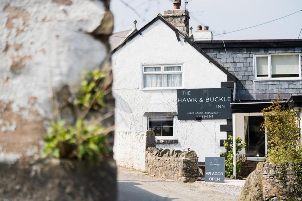 a white building with a sign in front of it at The Hawk & Buckle Inn in Llannefydd
