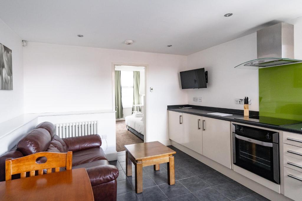 eine Küche und ein Wohnzimmer mit einem Sofa und einem Tisch in der Unterkunft H.V Apartments in Sheffield