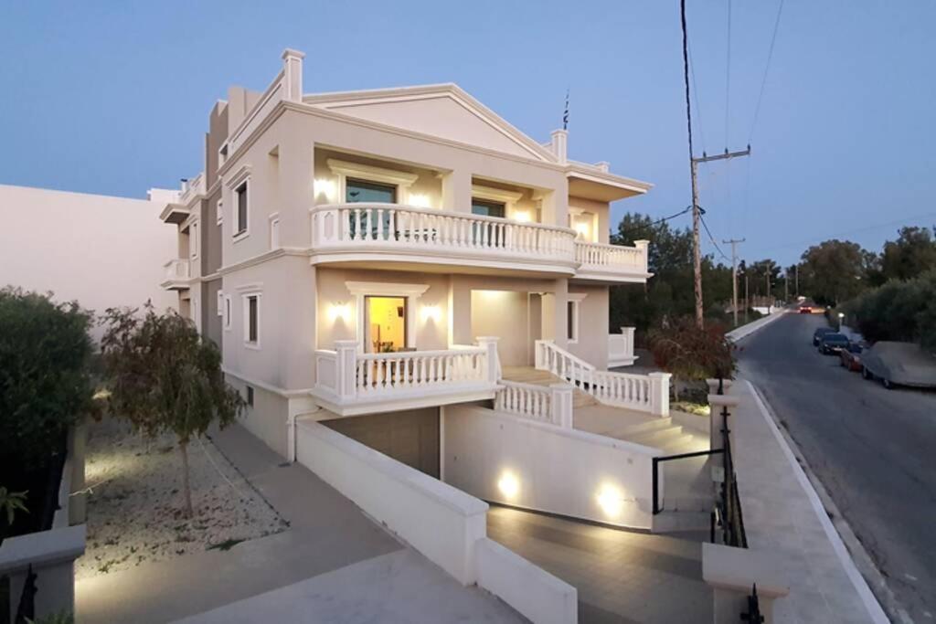 a white house with a balcony on a street at Olivia in Chania
