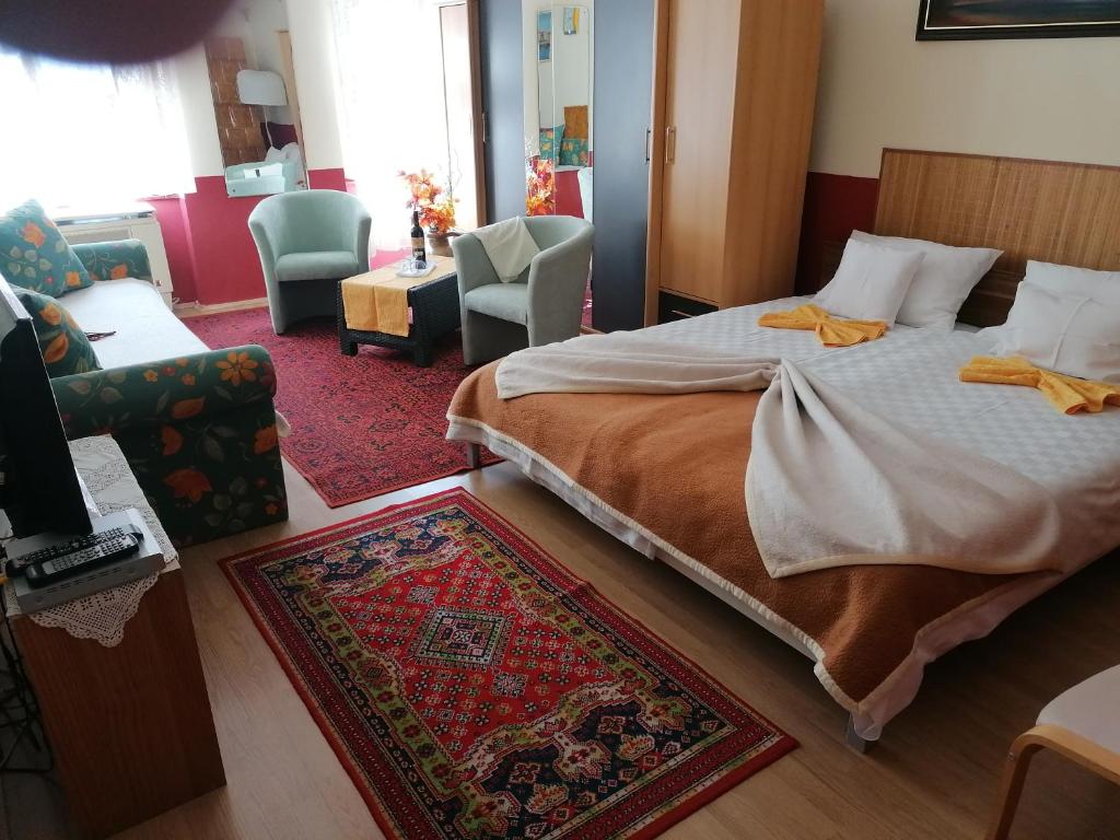 a bedroom with a bed and a living room at Róza vendégszoba in Keszthely