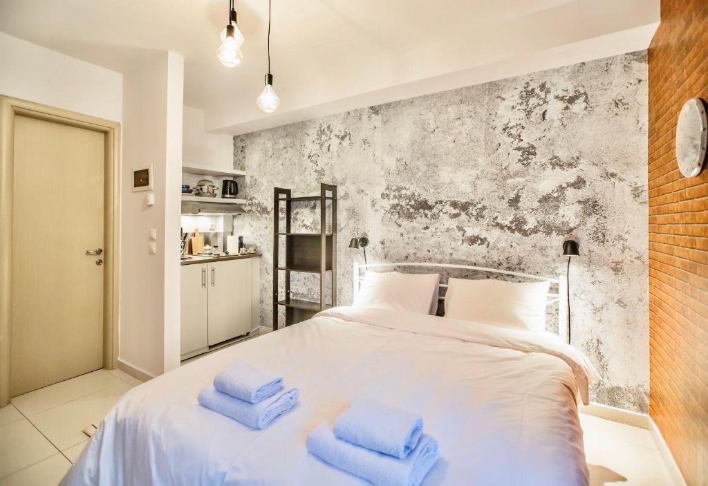 una camera da letto con un letto bianco e asciugamani blu di #Harmony Studios by halu! Apartments a Salonicco