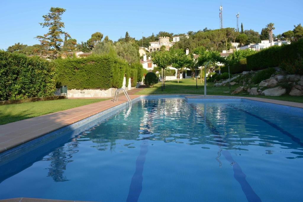 einen Pool mit blauem Wasser im Hof in der Unterkunft Casas Blanca 19 piscina barbacoa wifi in Tossa de Mar