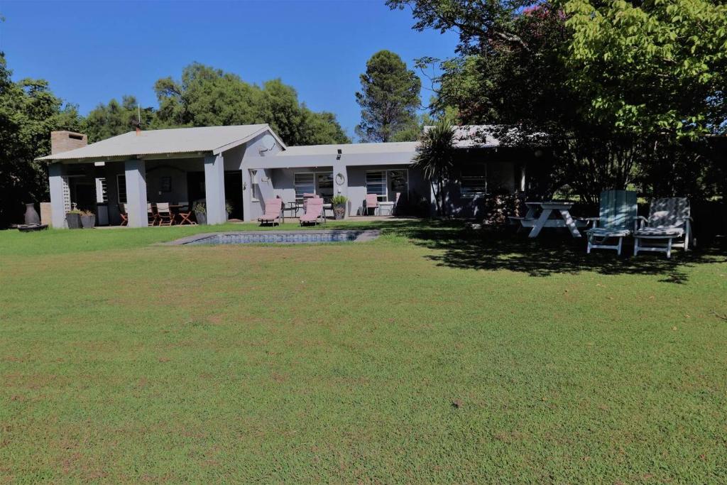 a house with a yard with chairs in front of it at Vaal River House @ Lochvaal in Vanderbijlpark