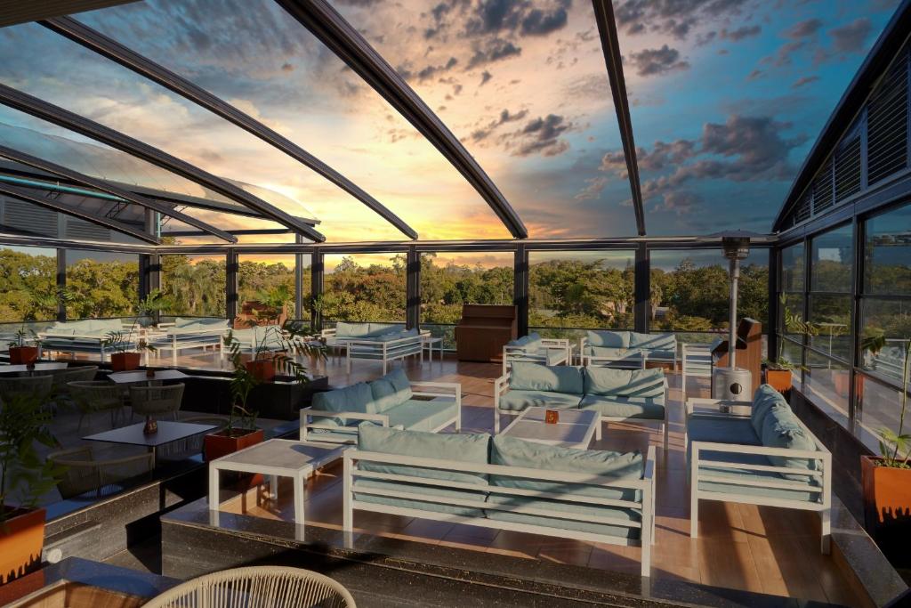 ein Restaurant mit blauen Stühlen und Tischen und einem Sonnenuntergang in der Unterkunft The Quorum in Lusaka