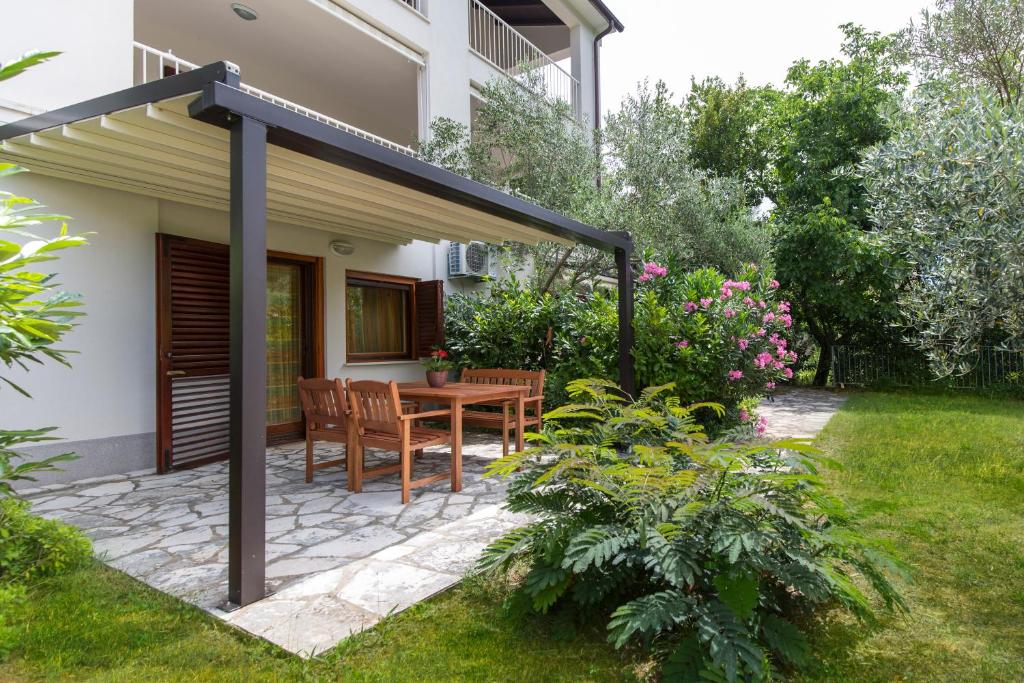 a patio with a table and chairs under an awning at Apartments Sveta Marina in Labin