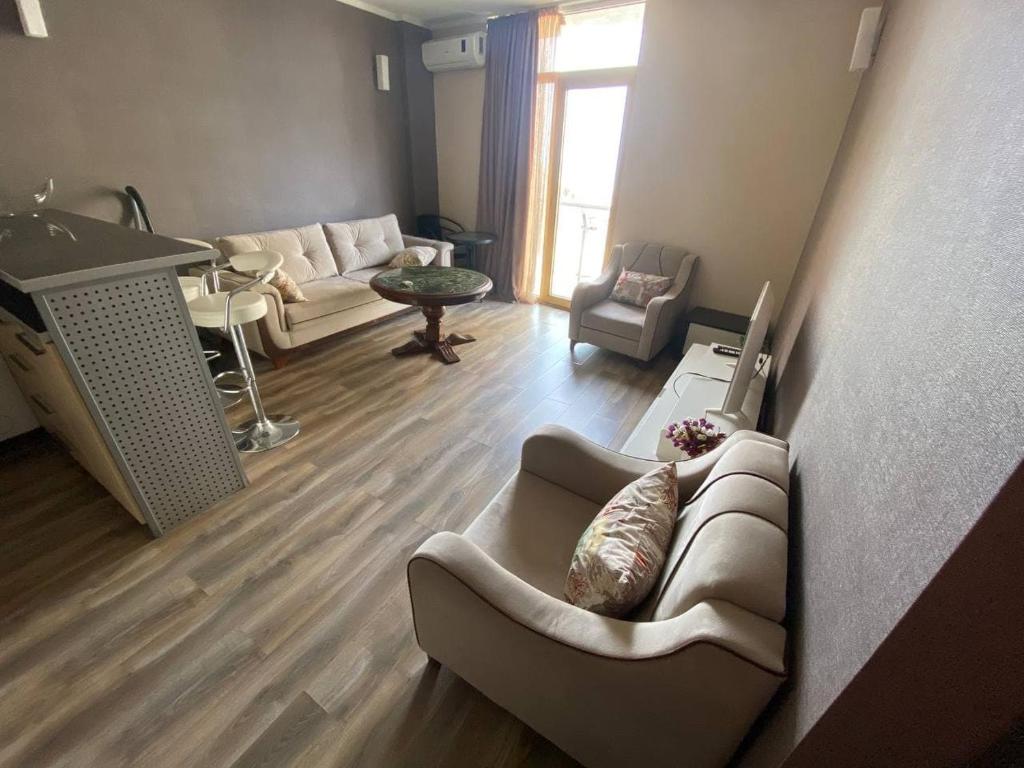 Orbi Plaza Apartment في باتومي: غرفة معيشة مع أريكة وطاولة