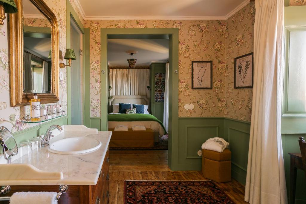 a bathroom with a sink and a bedroom at Rosegarden House - by Unlock Hotels in Sintra