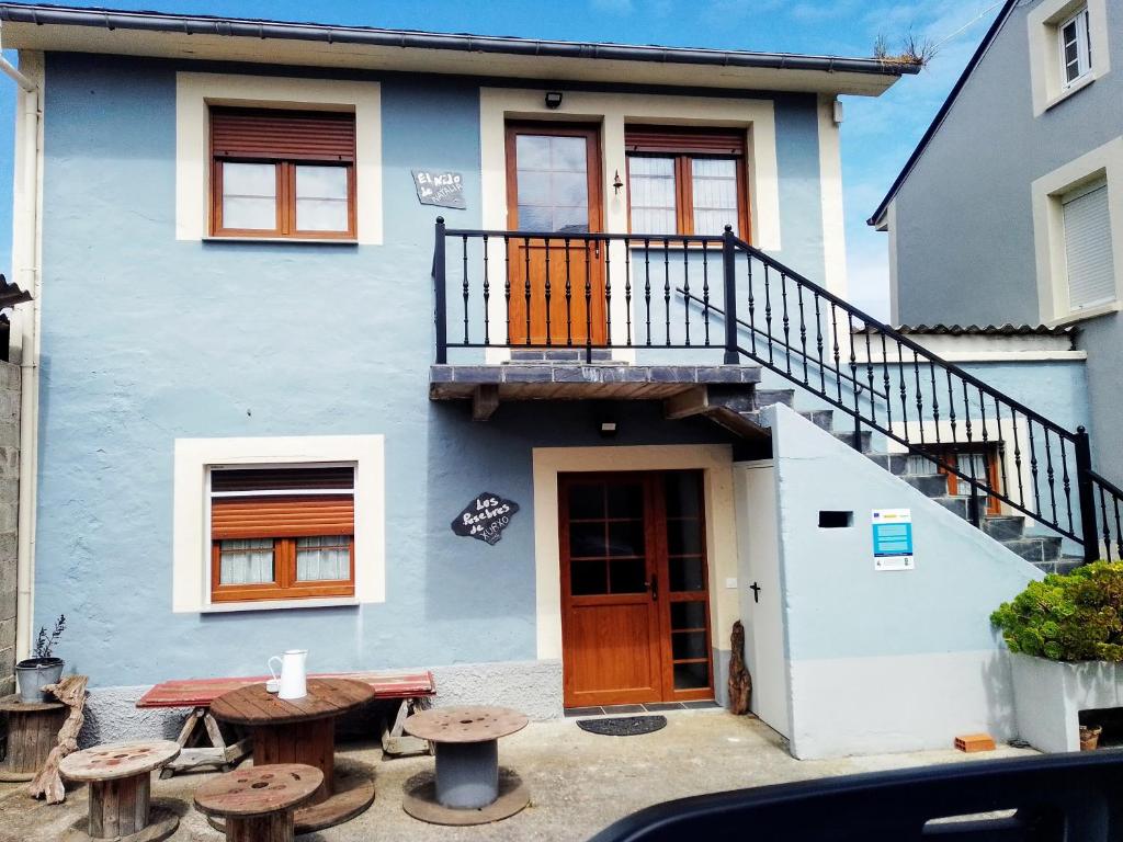 niebieski dom z drewnianymi drzwiami i stołem w obiekcie El Pajar de Lina w mieście Albarde