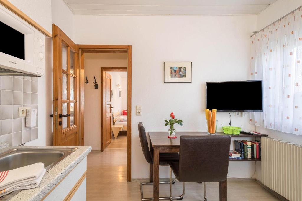 a kitchen and dining room with a table and a television at Haus Schneider in Kressbronn am Bodensee