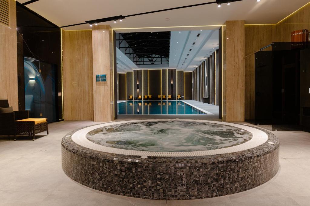 a jacuzzi tub in a lobby with a pool at Frankfort Hotel and Spa in Tashkent