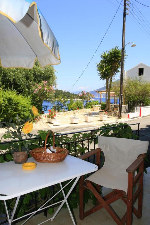 a table and chairs with a table and an umbrella at Kiki Studios in Fiskardo