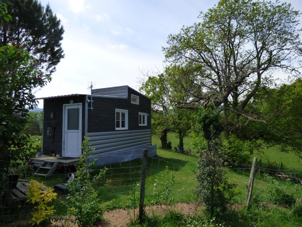 a tiny house in the middle of a yard at La tiny des 3 Pics in Bartrés