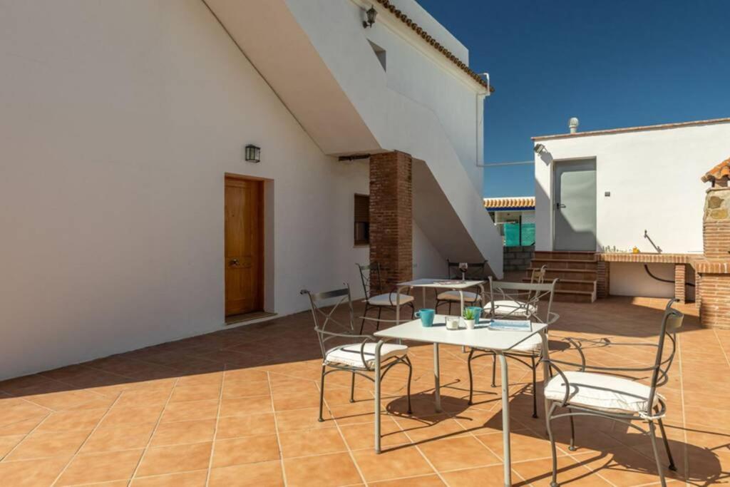patio z krzesłami i stołem w budynku w obiekcie Apartamento Bolonia Luz B w mieście Bolonia