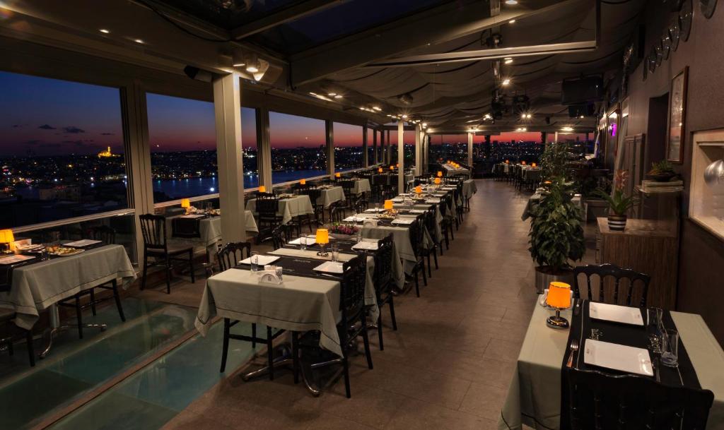 a restaurant with tables and chairs with a view at Hotel Troya in Istanbul