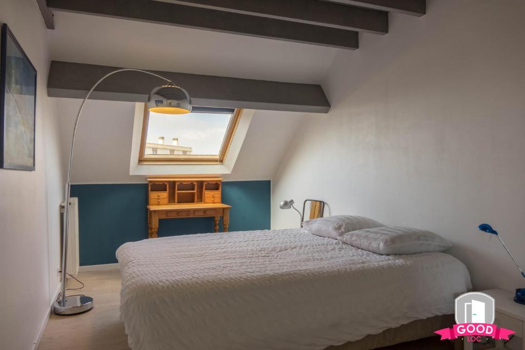 een slaapkamer met een groot bed en een raam bij Le Duplex Ensoleillé du Parc * Parking * Balcon * in Orléans