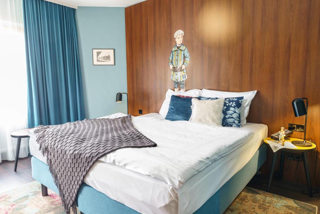 um quarto com uma cama com uma estátua em cima em Tante ALMA's Bonner Hotel em Bonn