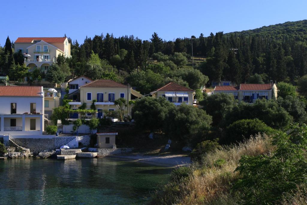 a group of houses on a hill next to a body of water at Kiki Studios in Fiskardo