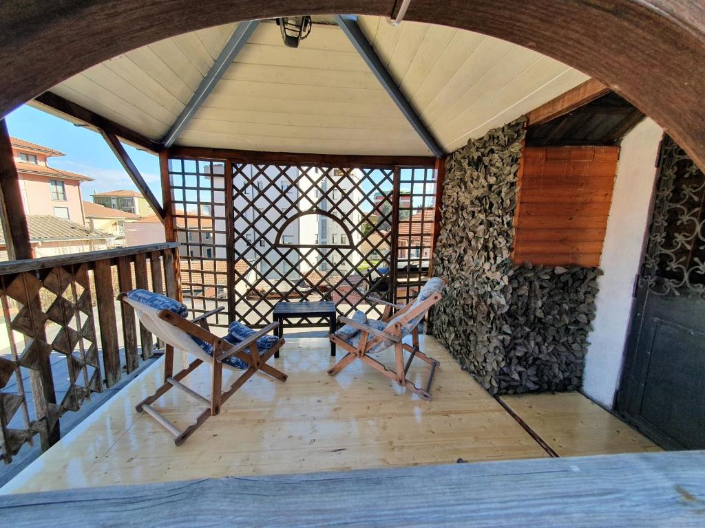 una camera con due sedie e un tavolo sul balcone di Typical mountain mansarda close to Fiera Rho Milano MIND a Pero
