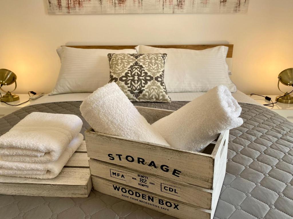a bedroom with a bed with a wooden box with towels at PORTA HOME modern and hospitable in Naxos Chora