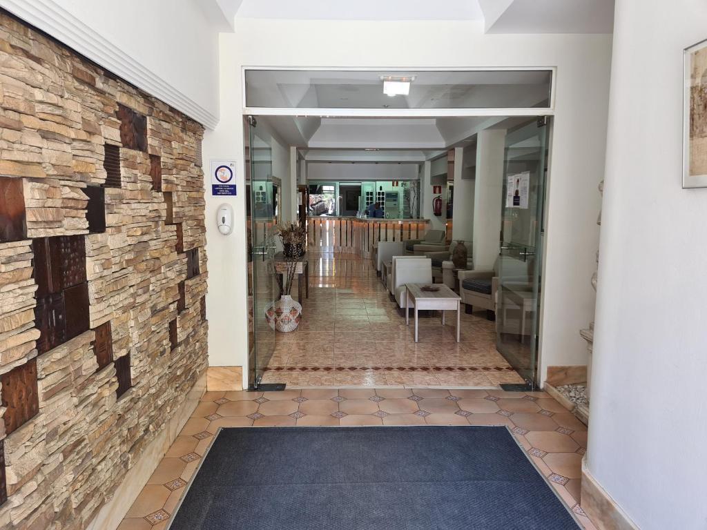 a hallway with a brick wall and a living room at Apartamentos Catalina Park in Las Palmas de Gran Canaria