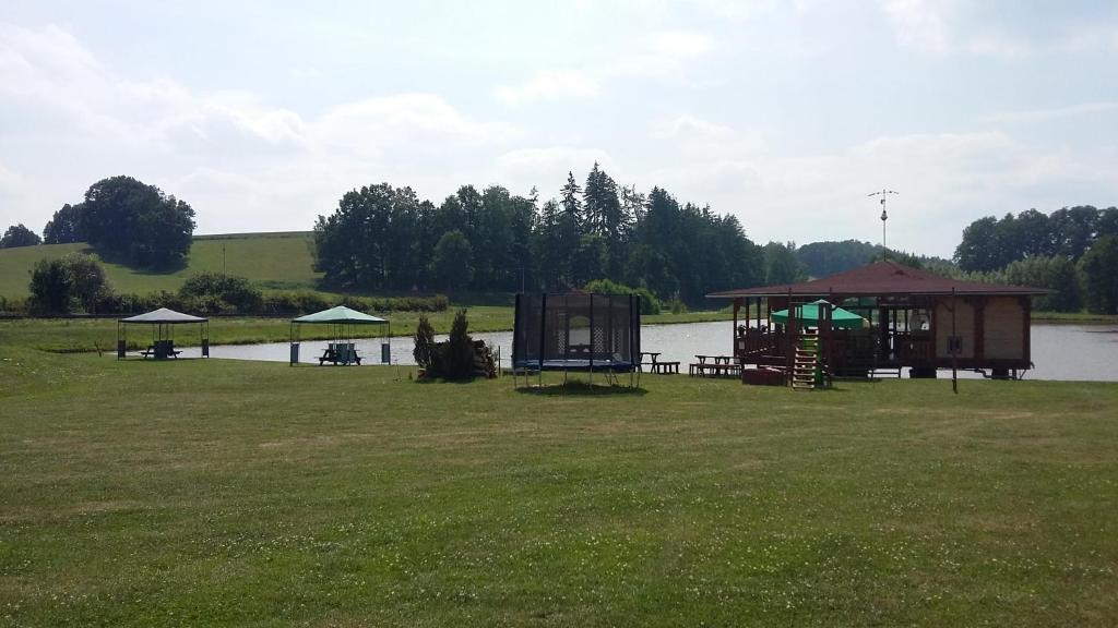 a picnic area next to a lake with a gazebo at Rybník Dalibor I in Vlcice