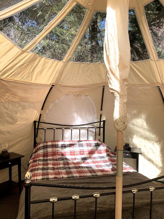 a bedroom with a canopy bed in a tent at Glamping at Camping La Source in Saint-Pierre-dʼArgençon