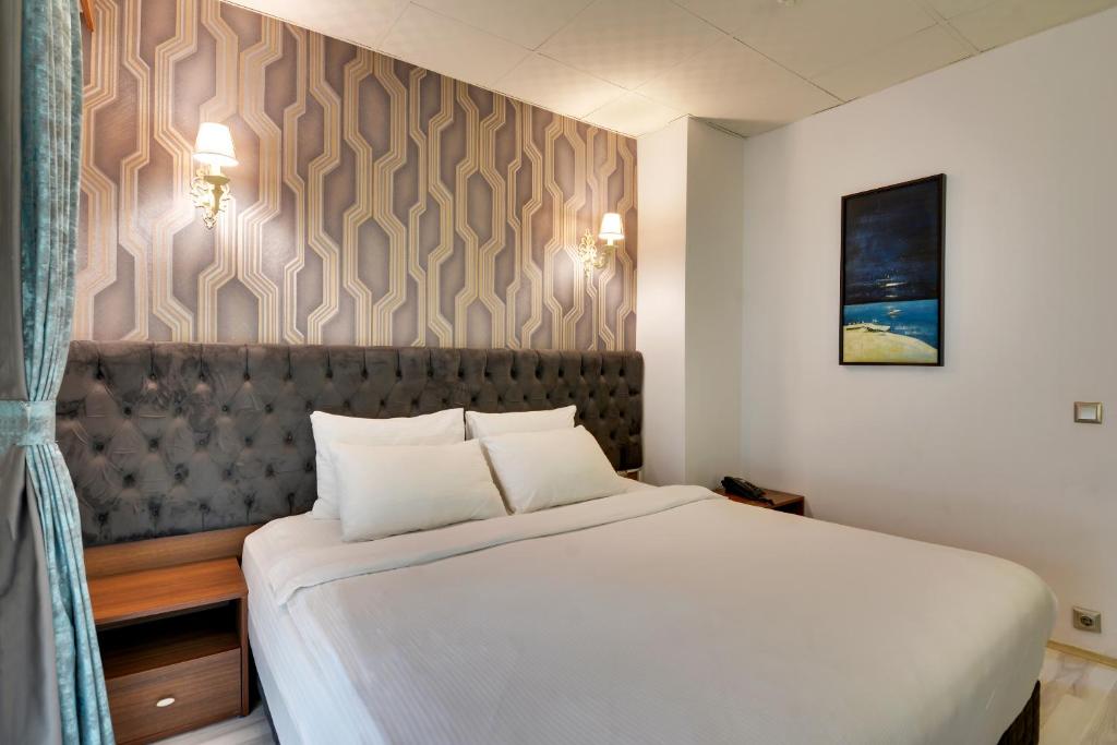 A bed or beds in a room at Grande Stella Hotel