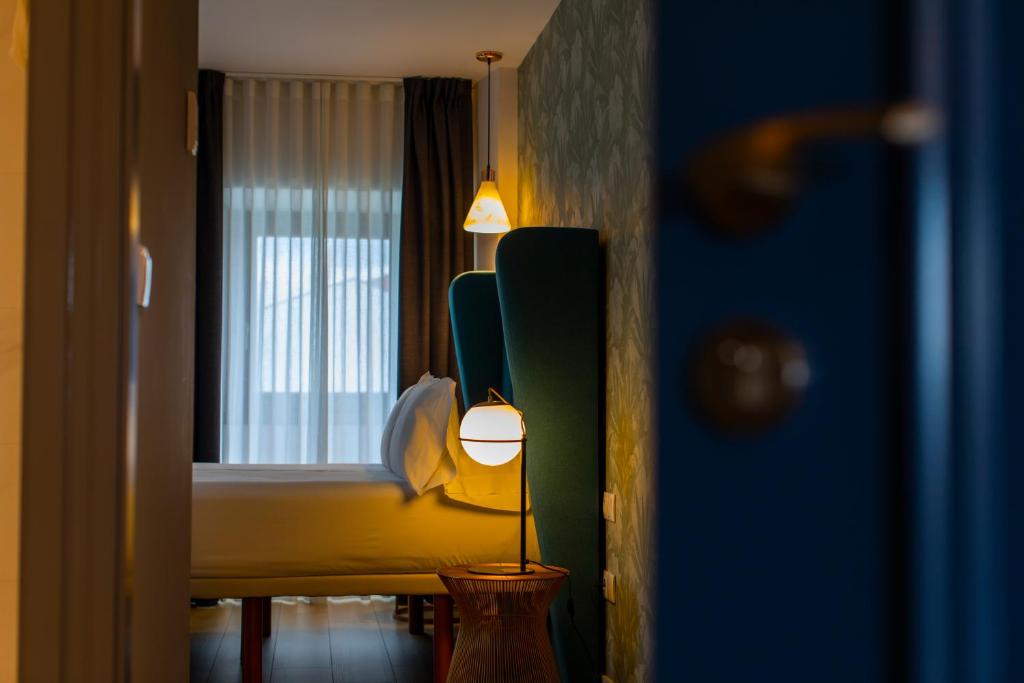 a bedroom with a bed and a lamp and a window at HOTEL JAVIER MONTERO in Ribadeo