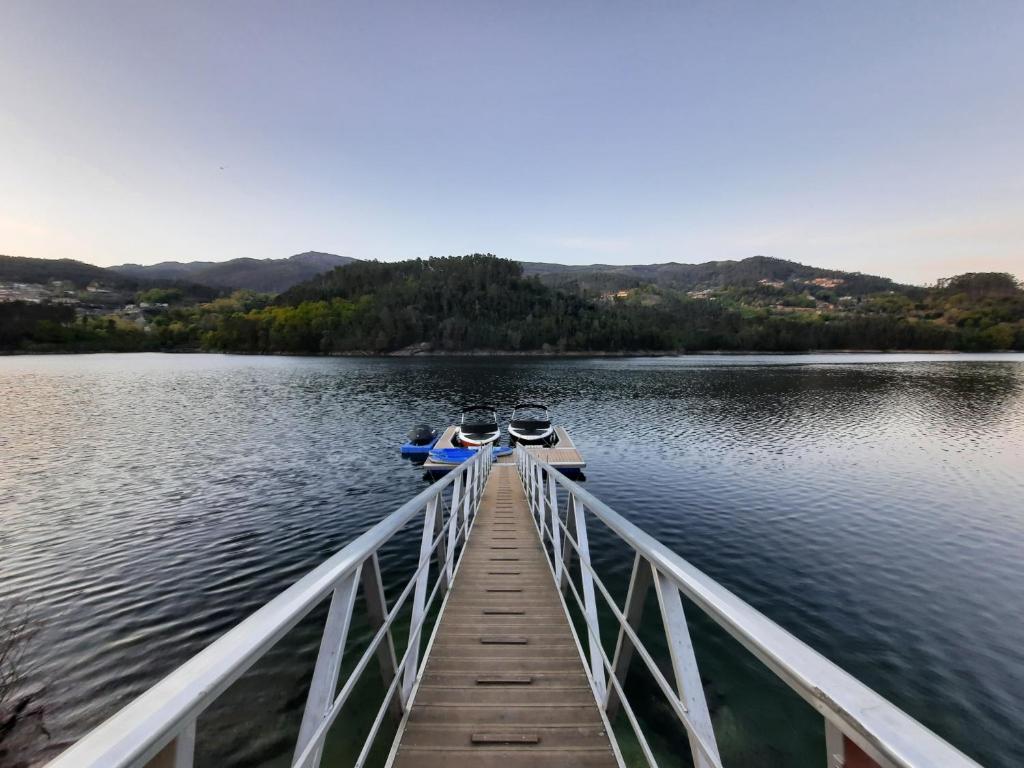 two boats are docked at a dock on a lake at Casa do Penedo - Quinta de Fundevilla in Geres