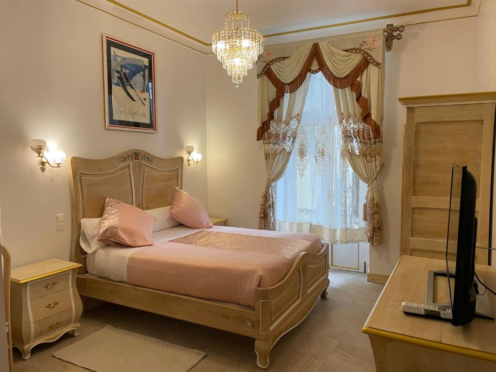 a bedroom with a bed and a desk and a television at Chambre Lyre Maison de L'Église du Couvent in Narbonne