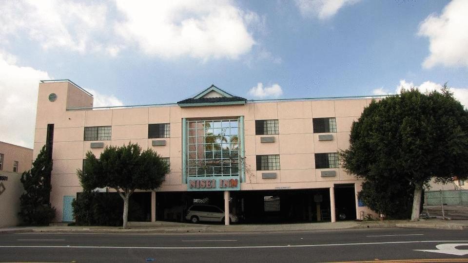 a building with a car parked in front of it at Nisei Inn in Gardena