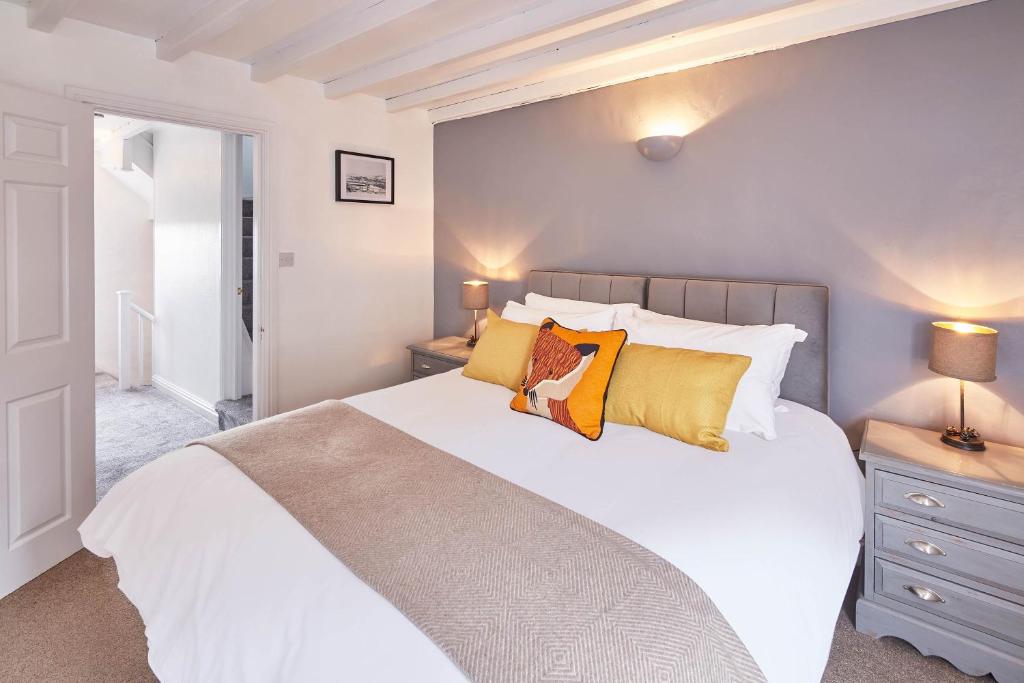 een slaapkamer met een groot wit bed met gele kussens bij Host & Stay - Dove Grey, 25 West End in Kirkbymoorside