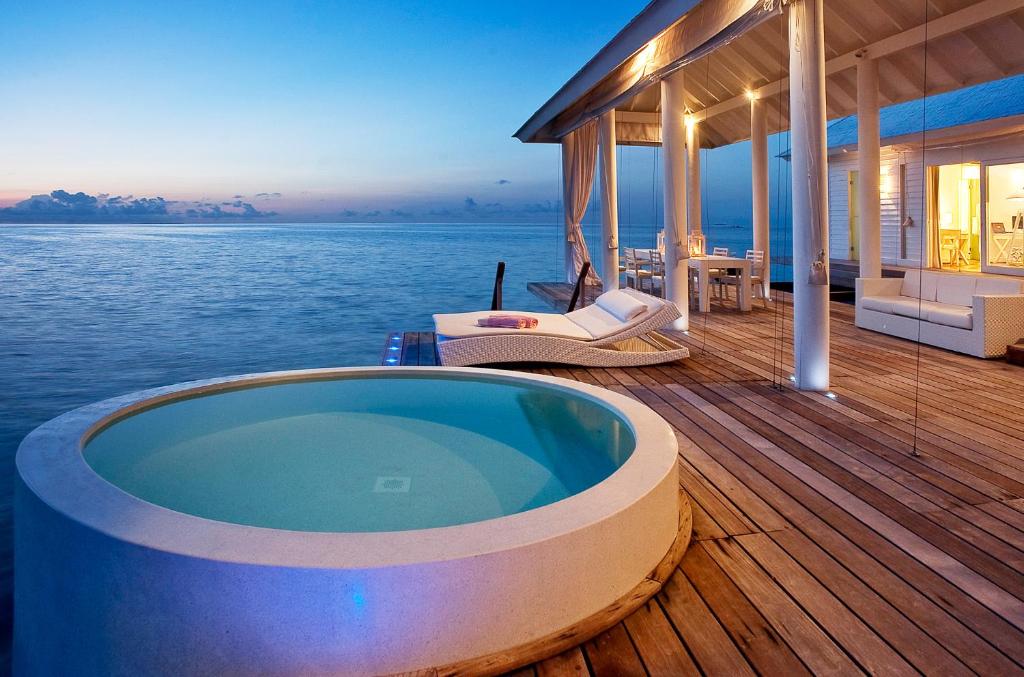 a jacuzzi tub on the deck of a house at Diamonds Athuruga Maldives Resort & Spa in Athuruga Island