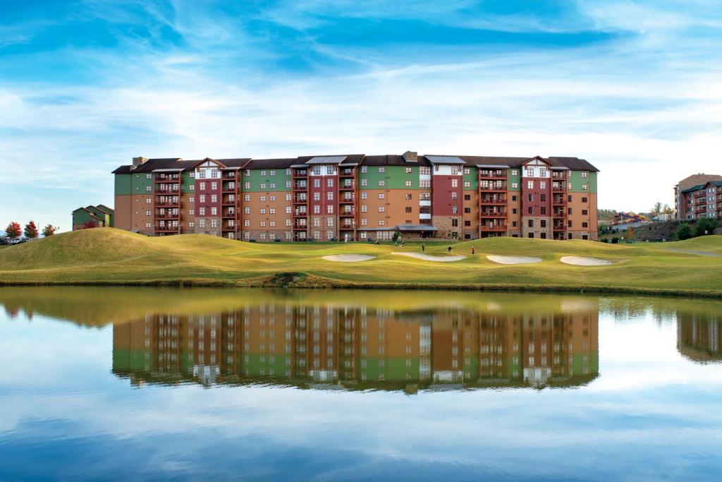 - un bâtiment sur un parcours de golf à côté d'une étendue d'eau dans l'établissement Club Wyndham Great Smokies Lodge, à Sevierville