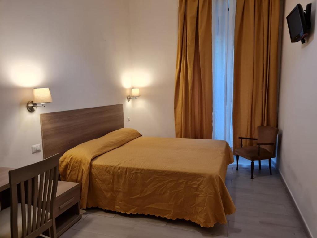 a hotel room with a bed and a chair at Albergo Enrica in Rome