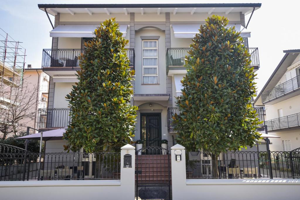 a house with three trees in front of it at Residence Valeria in Cervia