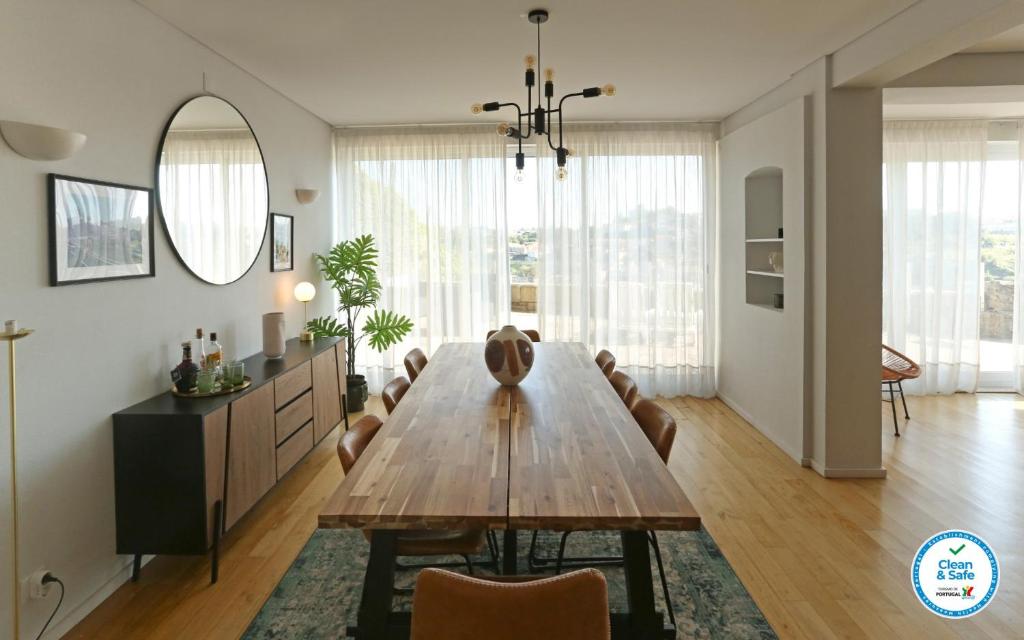 a dining room with a wooden table and chairs at Villa D'Ouro in Porto